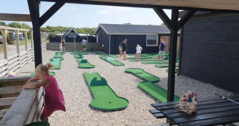 Minigolfbaan bij Toftum Bjerge Camping, waar gezinnen en kinderen samen van de buitenlucht genieten.