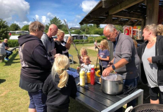 Familie griller og hygger udendørs ved Toftum Bjerge Camping, Central Denmark Region, Danmark.