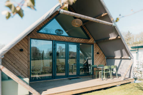 Big lodge at Holiday park De Boshoek in the Netherlands, exterior view with terrace and outdoor seating.