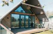 Stor hytte ved Holiday park De Boshoek i Holland, set udefra med terrasse og udendørs siddeplads.