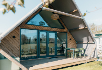 Gran cabaña en Holiday park De Boshoek en los Países Bajos, vista exterior con terraza y asientos fuera.