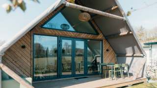Große Lodge im Ferienpark De Boshoek in den Niederlanden, Außenansicht mit Terrasse und Sitzbereich.