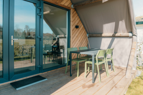 Terrasse extérieure avec chaises et table vertes à Big Lodge, Holiday park De Boshoek, Pays-Bas.