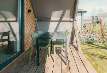 Buitenterras met groene stoelen en zwarte tafel bij Big lodge op Holiday park De Boshoek, Nederland.