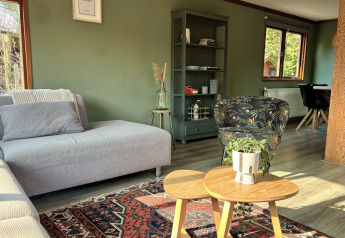 Sala de estar en Cozy Lodge de Bungalowpark Het Verscholen Dorp, Países Bajos, con decoración acogedora.