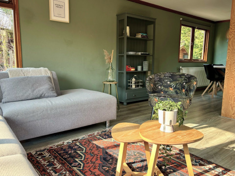 Woonruimte in Cozy Lodge op Bungalowpark Het Verscholen Dorp, Nederland, met warme sfeer en zonlicht.
