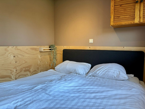 Camera accogliente con letto matrimoniale al Cozy Lodge nel Bungalowpark Het Verscholen Dorp, Paesi Bassi.