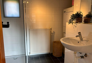 Moderne badeværelse i Cozy Lodge ved Bungalowpark Het Verscholen Dorp, Holland, med vask og bruser.