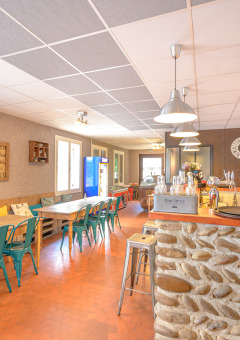 Accogliente area caffetteria al Camping Le Château in Auvergne-Rhône-Alpes, Francia, con bancone in pietra.