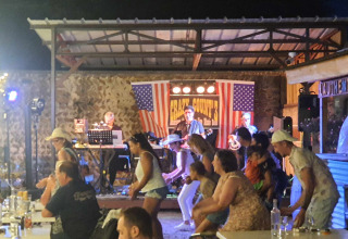 Abendveranstaltung mit Live-Countryband und tanzenden Gästen im Camping Le Château, Auvergne-Rhône-Alpes, Frankreich.