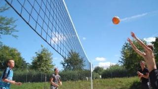 Ragazzi giocano a beach volley all'aperto al Camping Le Château in Alvernia-Rodano-Alpi, Francia.