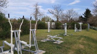 Area fitness all'aperto con attrezzi su prato al Camping Le Château in Auvergne-Rhône-Alpes, Francia.