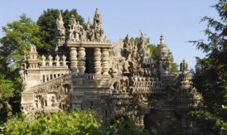 Il Palais Idéal du Facteur Cheval a Hauterives, Francia, circondato da alberi e vegetazione verde.