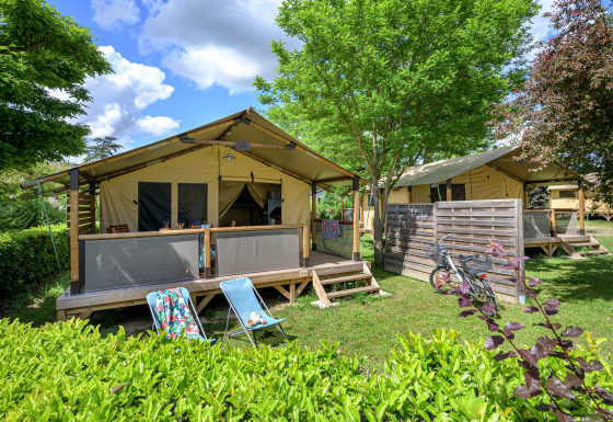 Safari-Zelt Lodge Bali Confort 30m² ohne eigenes Bad, gemütlich gelegen im Grünen mit Fahrrad davor.