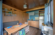 Moderne keuken en eethoek in Cottage Morea op Camping Le Château, Frankrijk, met houten inrichting.