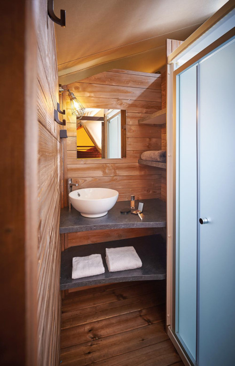 Bagno moderno con pareti in legno, lavabo tondo e doccia presso Lodge Kenya Vintage, Camping Le Château.