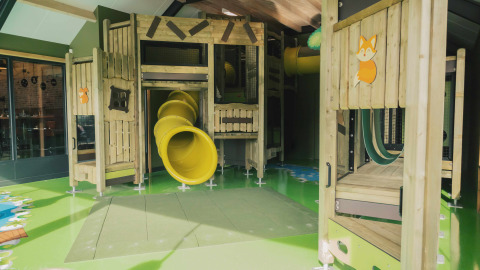 Overdekte speeltuin met glijbanen en houten structuren in Holiday park De Witte Berg, Overijssel, Nederland.