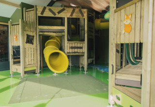 Indendørs legeplads med rutsjebaner og træstrukturer på Holiday park De Witte Berg i Overijssel, Holland.
