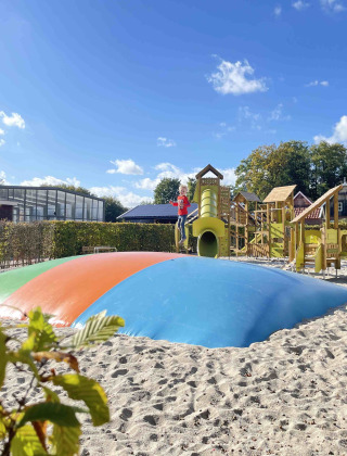 Parque infantil con cojín hinchable y estructura de escalada en Holiday park De Witte Berg en Overijssel, Países Bajos.