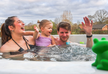 Famiglia felice che si diverte in una vasca idromassaggio allo stadio FC Mölke nel Holiday Park Mölke, Paesi Bassi.