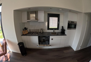 Cocina moderna en lodge Cannenburch en Veluwepark de Bosgraaf, Países Bajos, equipada con electrodomésticos.