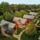 Luftfoto af hyggelige træhytter med jacuzzi ved Sandberghe lodge omgivet af grøn natur i Holland.
