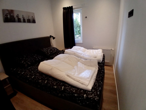 Gemütliches Schlafzimmer in der Forest Lodge De Mooie Plek, Bospark Markelo, Niederlande, mit Doppelbett.