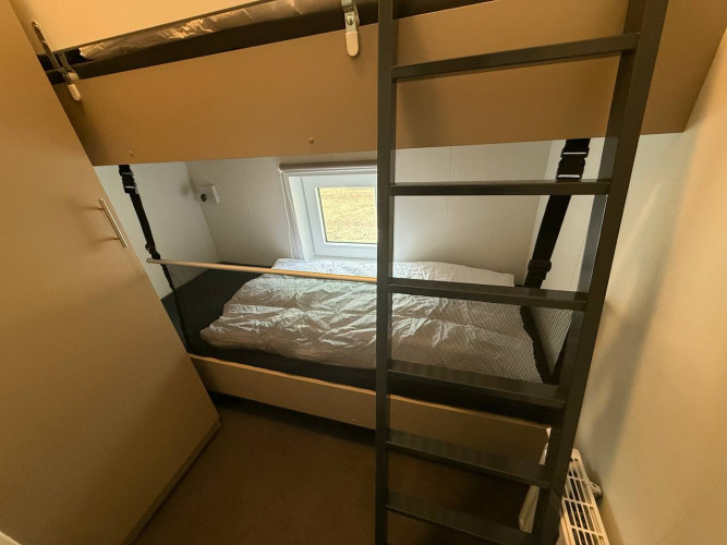 Kamer met stapelbed, ladder en raam in het Wood Cottage bij Holiday park De Witte Berg, Nederland.