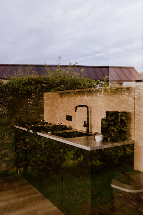 Weerspiegeling van groen in een tiny house keuken bij Holiday park Eigen Wijze, Nederland.