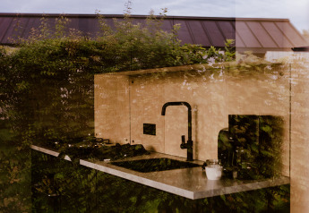 Weerspiegeling van groen in een tiny house keuken bij Holiday park Eigen Wijze, Nederland.