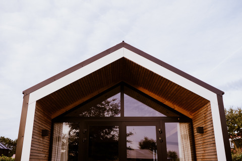 Moderne tiny house med trægavl og store vinduer i Holiday park Eigen Wijze, Nederlandene, set udefra.