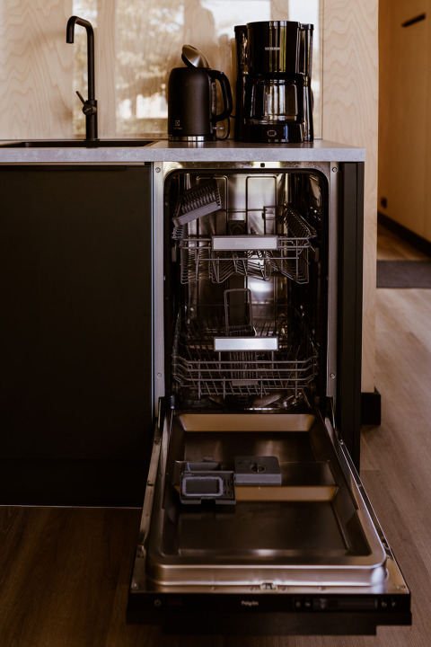 Lave-vaisselle ouvert dans une tiny house au Holiday park Eigen Wijze aux Pays-Bas, avec bouilloire et cafetière dessus.