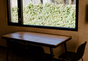 Dining area inside a tiny house at Holiday park Eigen Wijze, Netherlands, with table and window view.