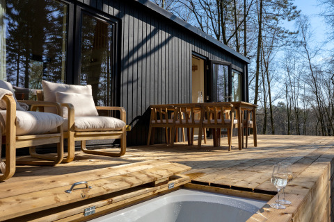 Buitenterras bij Koya Tiny Cabin met houten meubilair en boszicht in Wilsumer Berge, Duitsland.