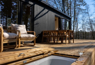 Terrazza esterna della Koya Tiny Cabin con mobili in legno e vista sul bosco a Wilsumer Berge, Germania.