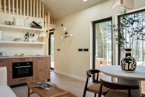 Lys og moderne interiør i Koya Tiny Cabin ved Wilsumer Berge, Tyskland, med åbent køkken og spiseplads.