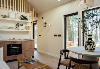 Lys og moderne interiør i Koya Tiny Cabin ved Wilsumer Berge, Tyskland, med åbent køkken og spiseplads.