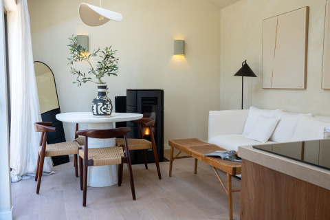 Modernes, gemütliches Interieur in der Koya Tiny Cabin im Wilsumer Berge, Deutschland, mit Esstisch und Sofa.