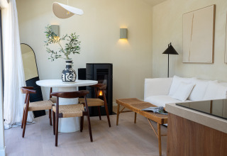 Modernes, gemütliches Interieur in der Koya Tiny Cabin im Wilsumer Berge, Deutschland, mit Esstisch und Sofa.