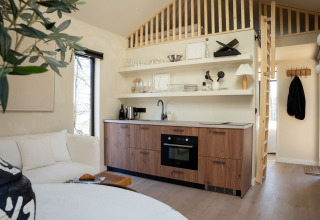 Modern gestaltete kleine Küche in der Koya Tiny Cabin, Wilsumer Berge, Deutschland, mit Holzdetails.