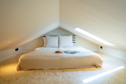 Gemütliches Schlafzimmer in der Koya Tiny Cabin im Wilsumer Berge, Deutschland, mit niedrigem Dachgeschoss.