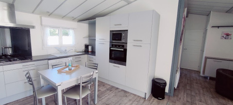 Cocina moderna y comedor en un lodge CRL 1/5 pers. en Camping Seasonova Les Vosges du Nord, Francia.