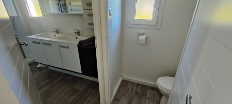 Badkamer met dubbele wastafel en apart toilet in een lodge bij Camping Seasonova Les Vosges du Nord.