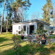 Forest Lodge De Mooie Plek bij Bospark Markelo in Nederland, omgeven door bomen en een groen gazon.