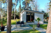 Forest Lodge De Mooie Plek bij Bospark Markelo in Nederland, omringd door bomen en groene tuin.
