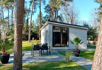 Forest Lodge De Mooie Plek en Bospark Markelo, Países Bajos, rodeado de árboles y césped verde.