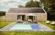 Moderne lodge Unbrick One med sauna, pool, solpaneler og hyggelig terrasse i grønne omgivelser.