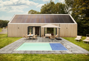 Lodge Unbrick One avec sauna, piscine, panneaux solaires et terrasse accueillante dans un cadre verdoyant.