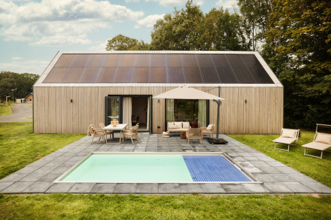 Lodge Unbrick One avec sauna, piscine, panneaux solaires et terrasse accueillante dans un cadre verdoyant.