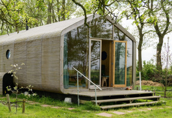 Wrap house lodge con sauna e vasca da bagno al Resort de Parel, Paesi Bassi, immerso nel verde.